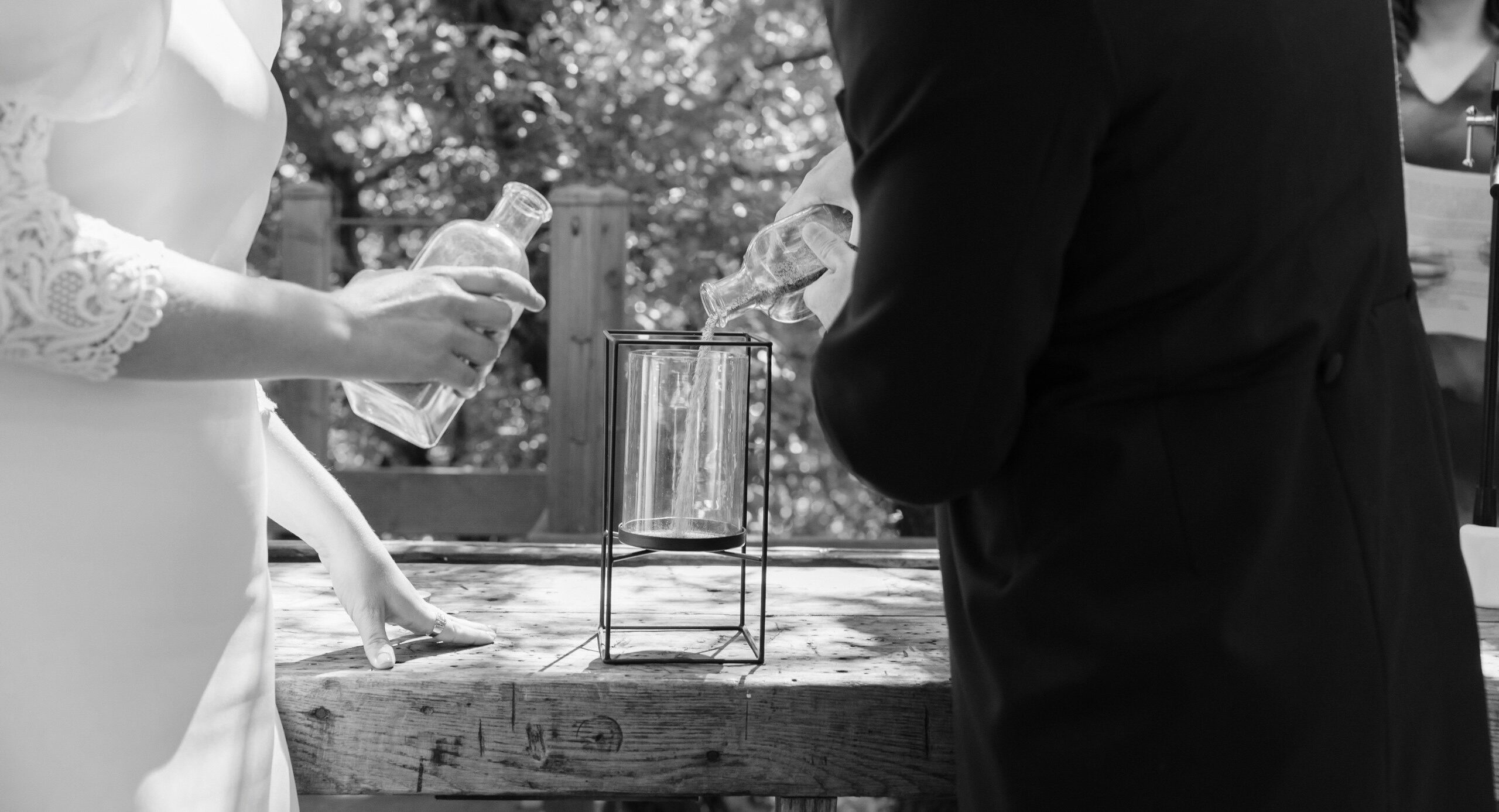 Una pareja realiza el rito de la arena en una boda civil.